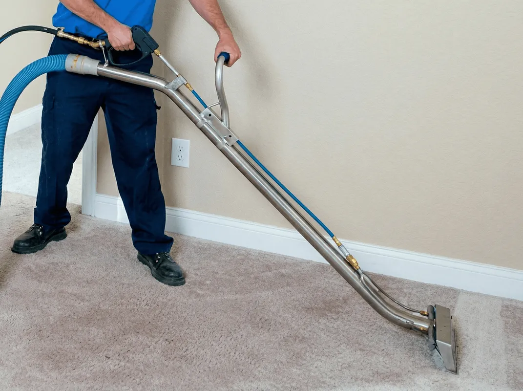 Professional operating a liquid removal machine on a carpeted floor in Peoria, IL